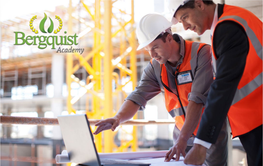 Two men looking at a laptop on a jobsite